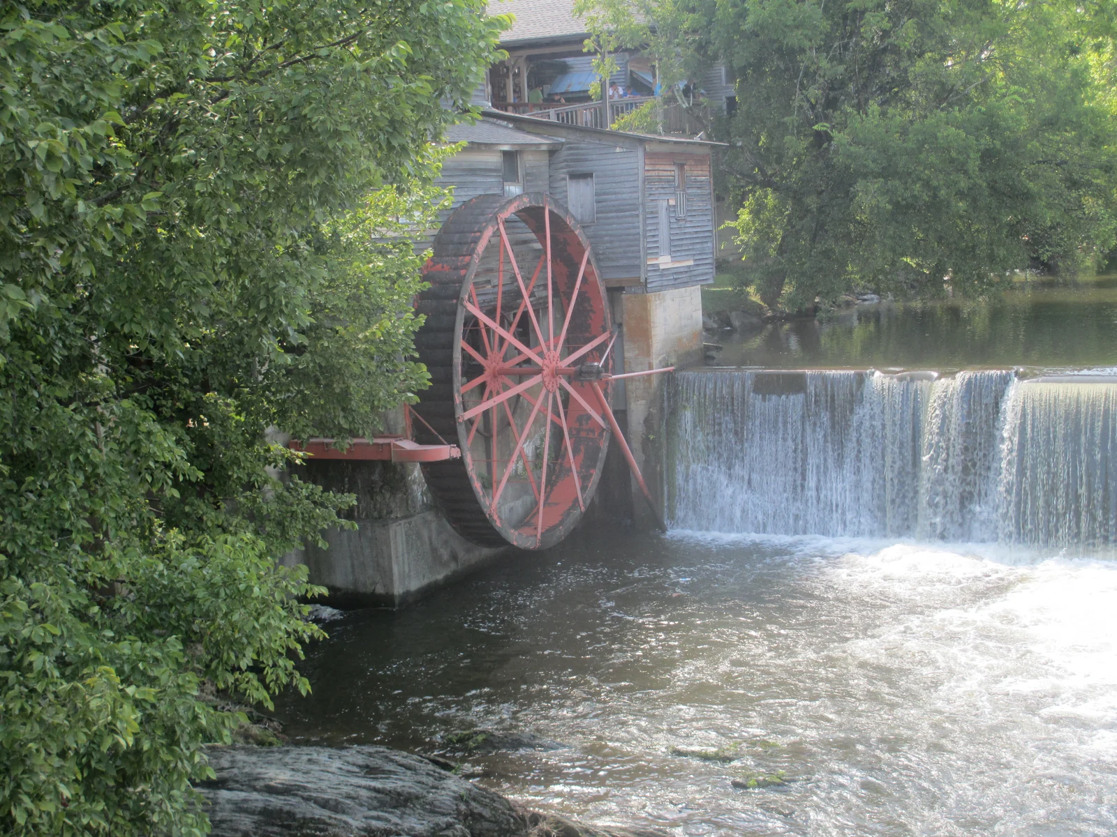 The Old Mill building and waterwheel beside the Little Pigeon River in Pigeon Forge